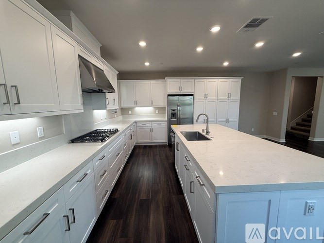 A modern kitchen with white cabinets and a blue island.