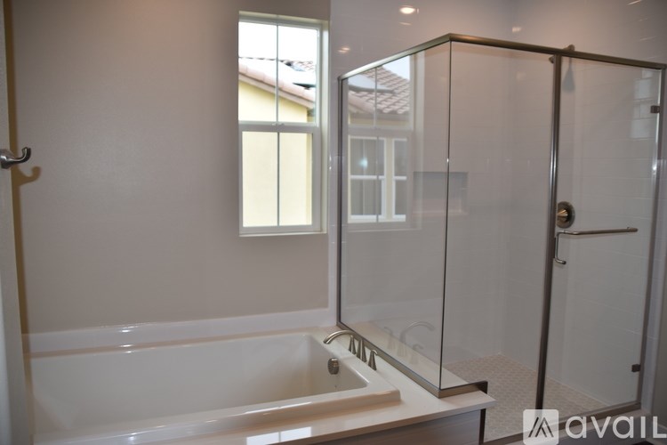 A bathroom with a glass shower door and a bathtub.