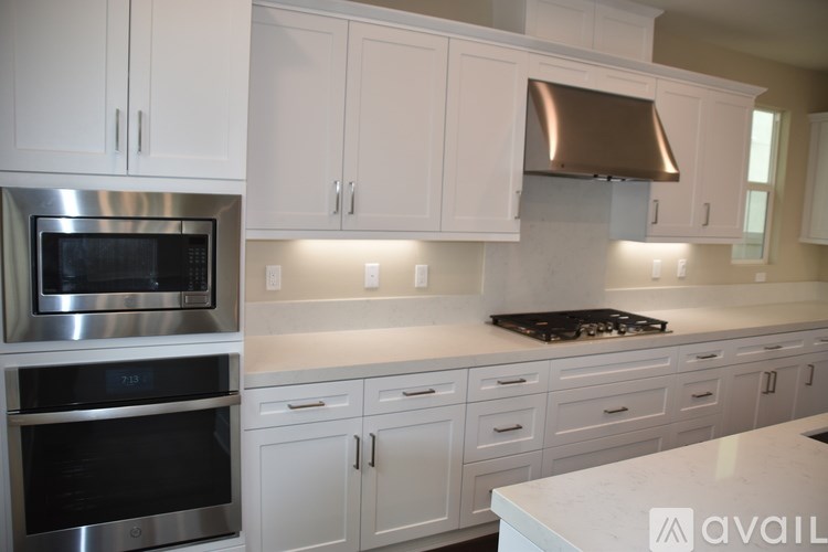 A kitchen with white cabinets and a stainless steel oven.