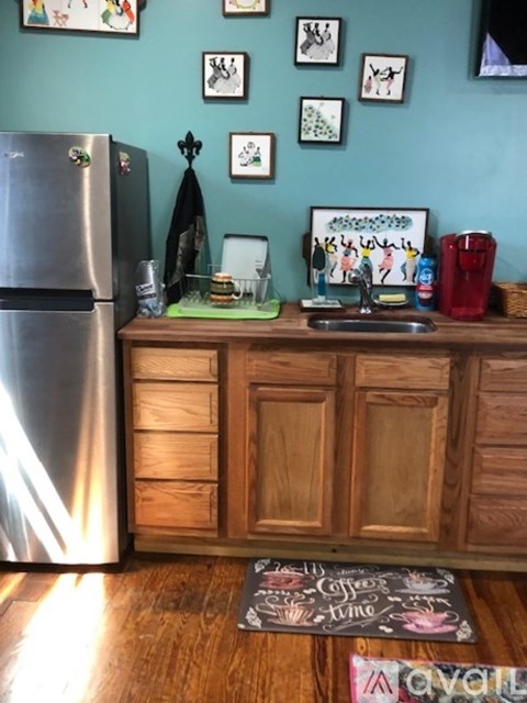 A kitchen with a wooden counter and a fridge.