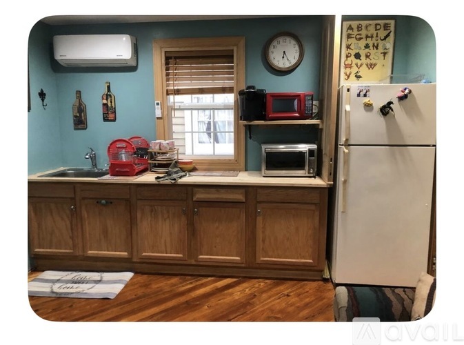 A kitchen with a stainless steel refrigerator and wooden cabinets.