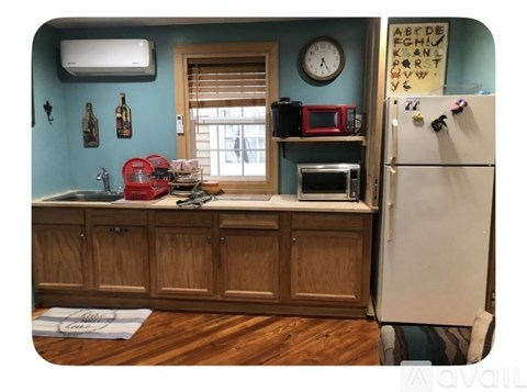 A kitchen with a stainless steel refrigerator and wooden cabinets.