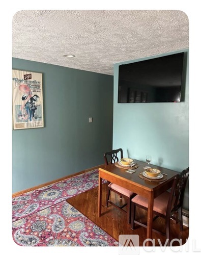 A kitchen with a wooden counter and a TV mounted on the wall.