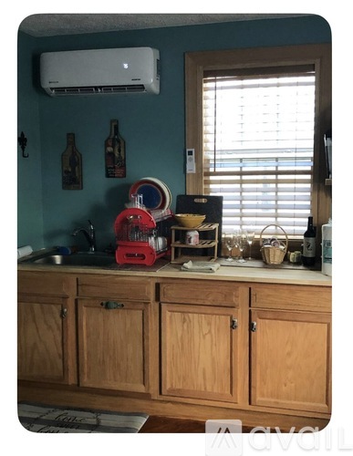 A kitchen with a stainless steel refrigerator and a wooden countertop with a sink.