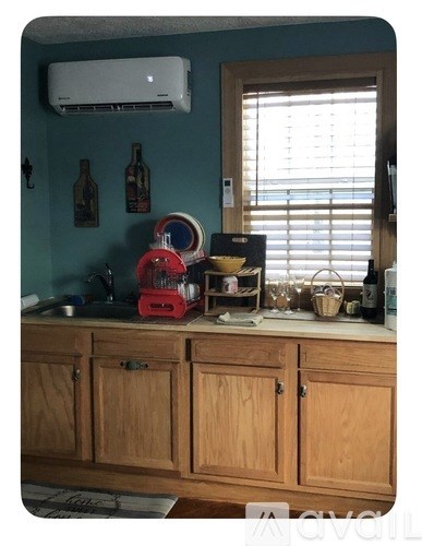 A kitchen with a stainless steel refrigerator and a wooden countertop with a sink.