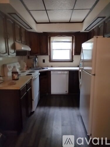 A kitchen with a white fridge and a white dishwasher.