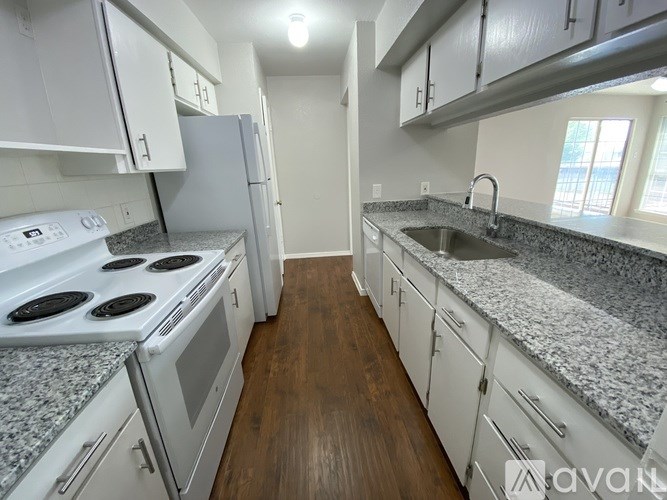 A kitchen with white cabinets and a granite countertop.