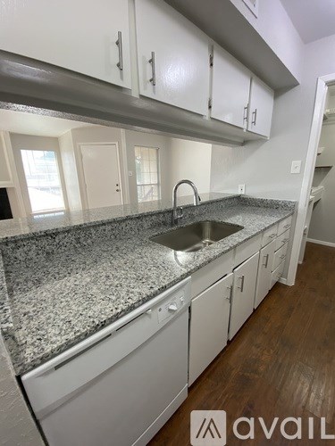 A kitchen with granite countertops and white cabinets.