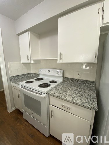 A kitchen with a granite countertop and white appliances.