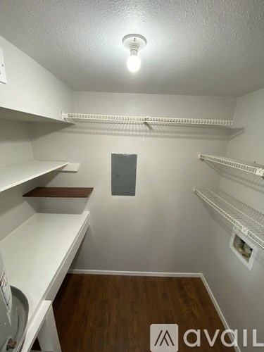 A small, empty room with a white door and a light on the ceiling.