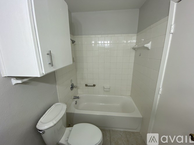 A white toilet and bathtub in a small bathroom.