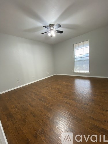A room with wooden flooring and a ceiling fan.