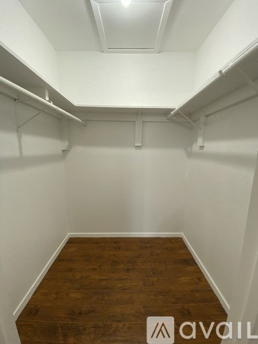 A room with white walls and wooden flooring with a white ceiling.