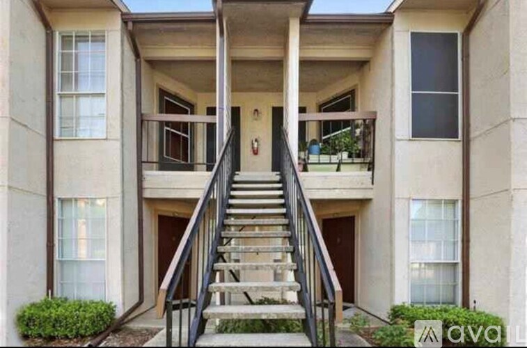 A balcony with a railing and steps leading to a door.
