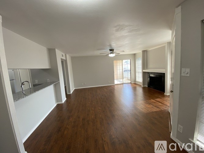 A spacious living room with hardwood floors and a ceiling fan.