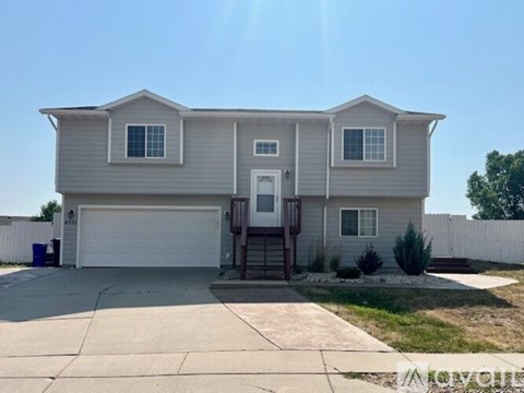 A two-story house with a garage and a driveway.