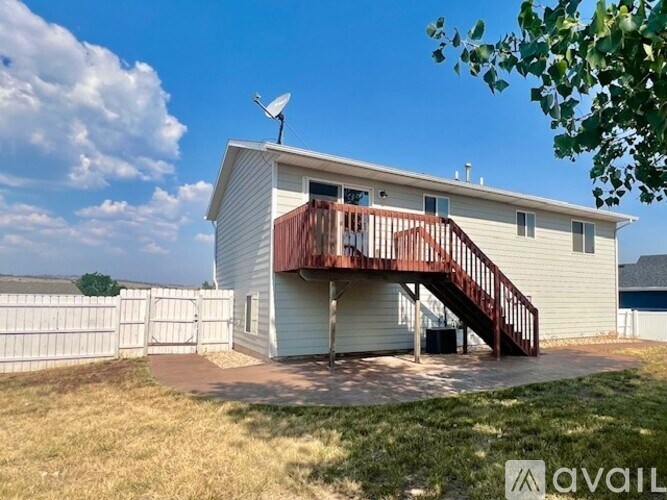 A house with a white fence and a red deck is for sale.