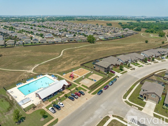 A bird's eye view of a residential area with a swimming pool and a parking lot.