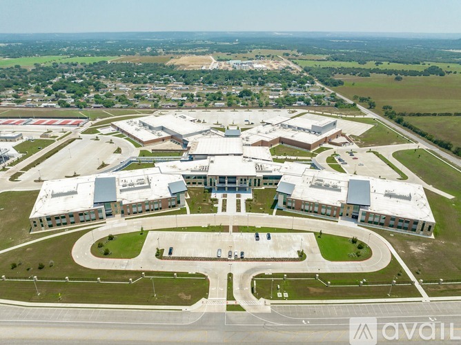 An aerial view of a large building complex with a parking lot in front.