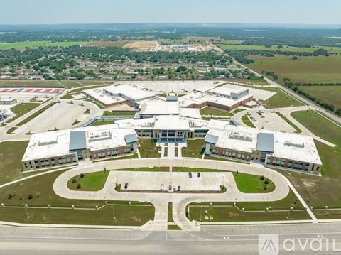 An aerial view of a large building complex with a parking lot in front.