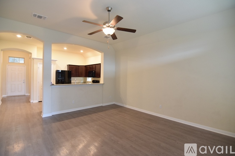 A spacious room with a ceiling fan and a wall-mounted TV.