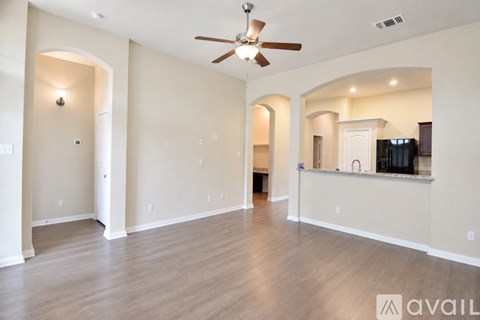 A spacious room with a ceiling fan and a wall-mounted TV.