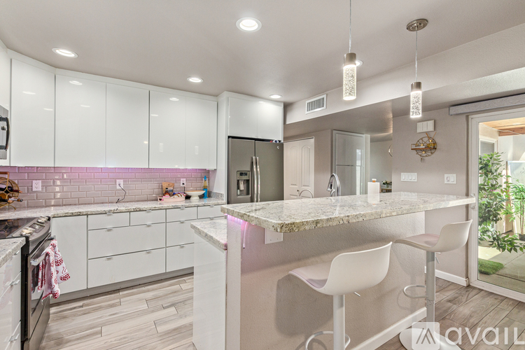 A modern kitchen with white cabinets and a marble countertop.