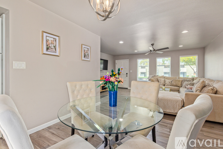 A modern dining room with a glass table and chairs.