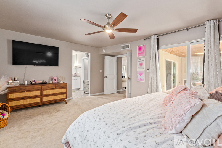 A bedroom with a large bed and a flat screen TV mounted on the wall.