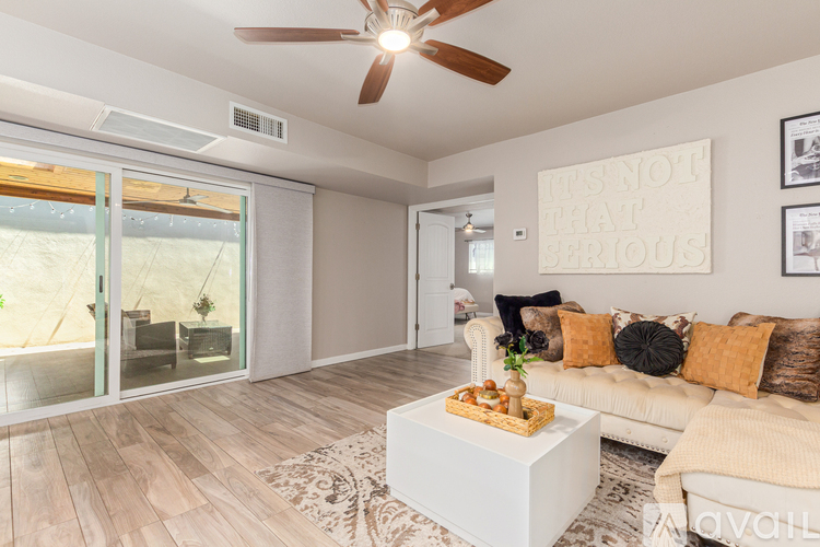A living room with a white couch and a wooden coffee table.