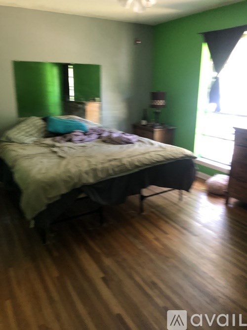A bedroom with a bed, nightstand, and lamp.