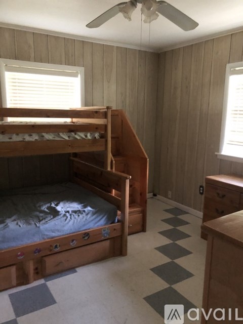 A bedroom with a bunk bed and a dresser.