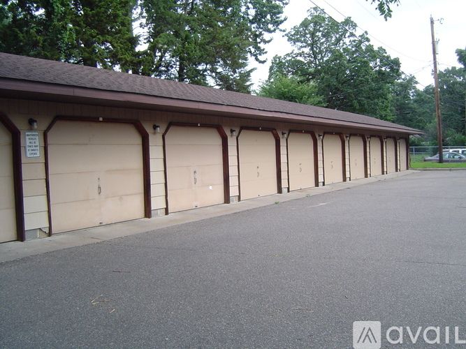 A long building with a brown roof and tan garage doors.