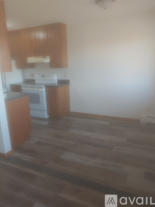 A kitchen with wooden cabinets and a black counter top.