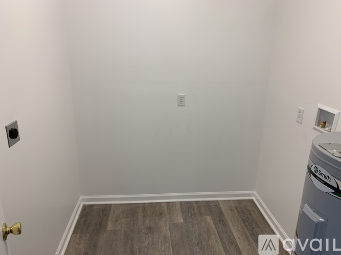 A room with a door, a wall socket, and a washing machine.