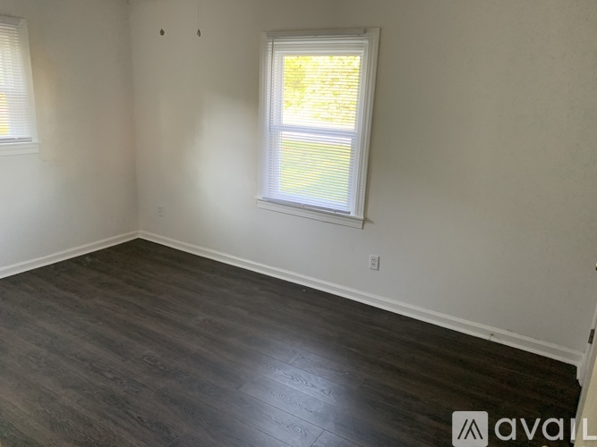 A room with a window and wooden flooring is available for rent.