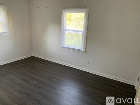A room with a window and wooden flooring is available for rent.