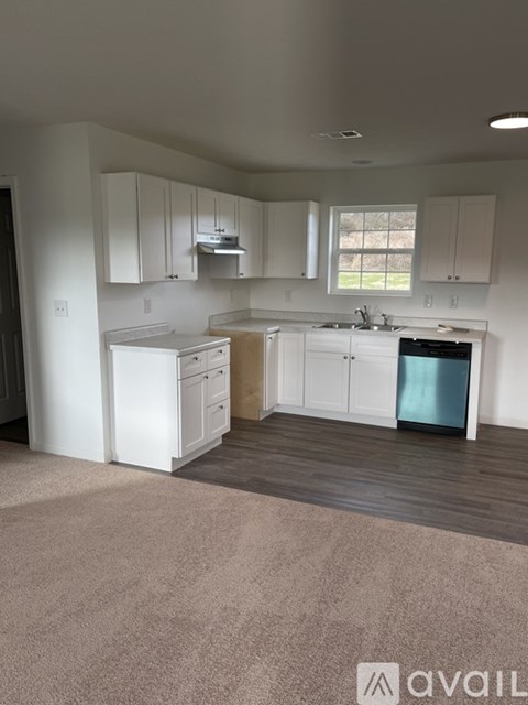 A kitchen with white cabinets and a blue dishwasher.