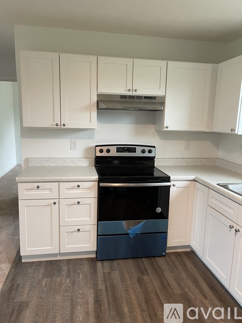 A kitchen with white cabinets and a black stove top oven.