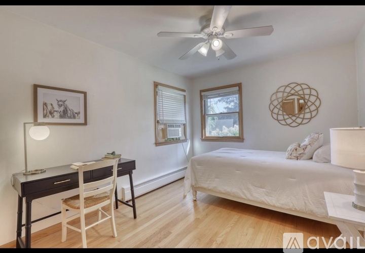 A bedroom with a bed, desk, and chair.