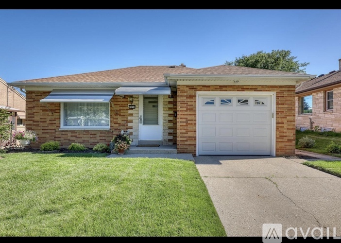 A house with a white garage door and a brown brick exterior.