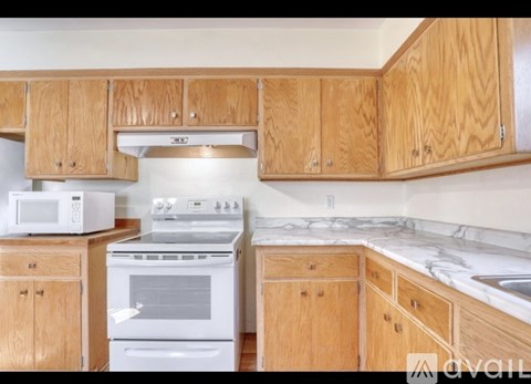 A kitchen with wooden cabinets and a white oven.