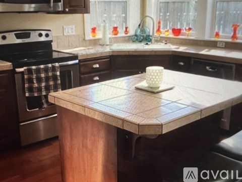 A kitchen with a checkered towel hanging on the oven door.