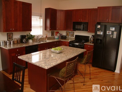 A kitchen with brown cabinets and a granite countertop.