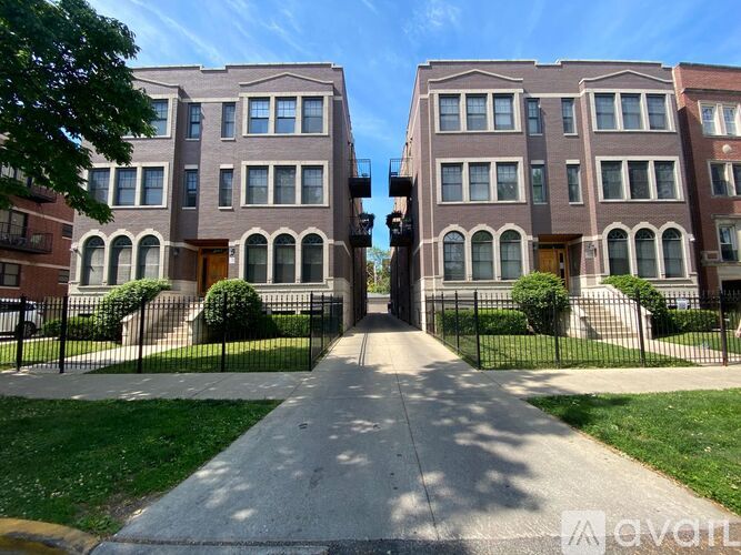 A street view of a residential area with two-story buildings and a sidewalk.