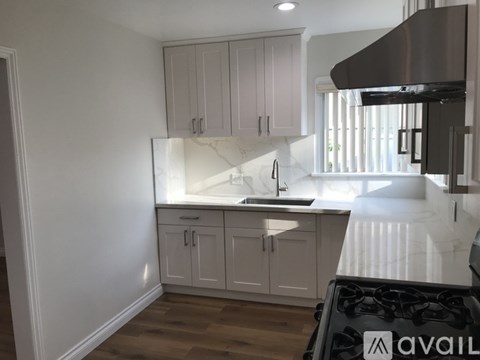 A kitchen with white cabinets and a black stove top.