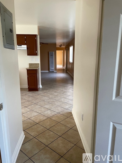 A hallway with a tile floor and white walls.