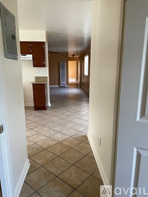 A hallway with a tile floor and white walls.
