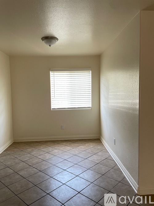 A room with a window and tiled floor.