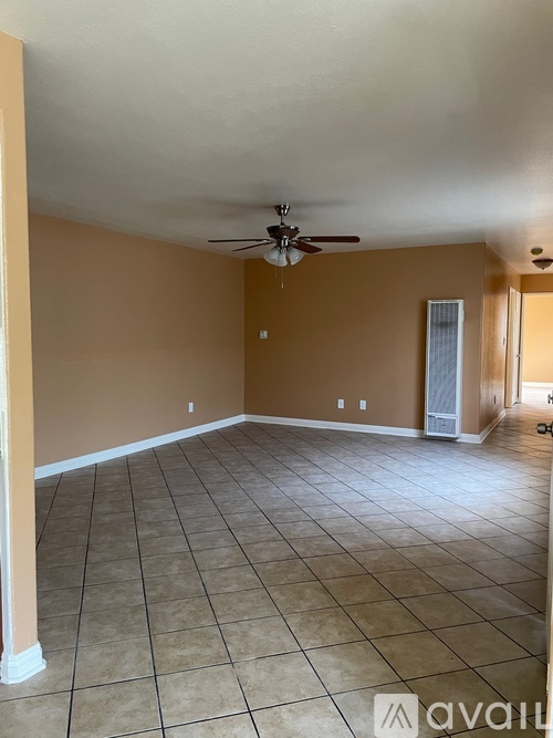 A spacious room with a ceiling fan and tile flooring.
